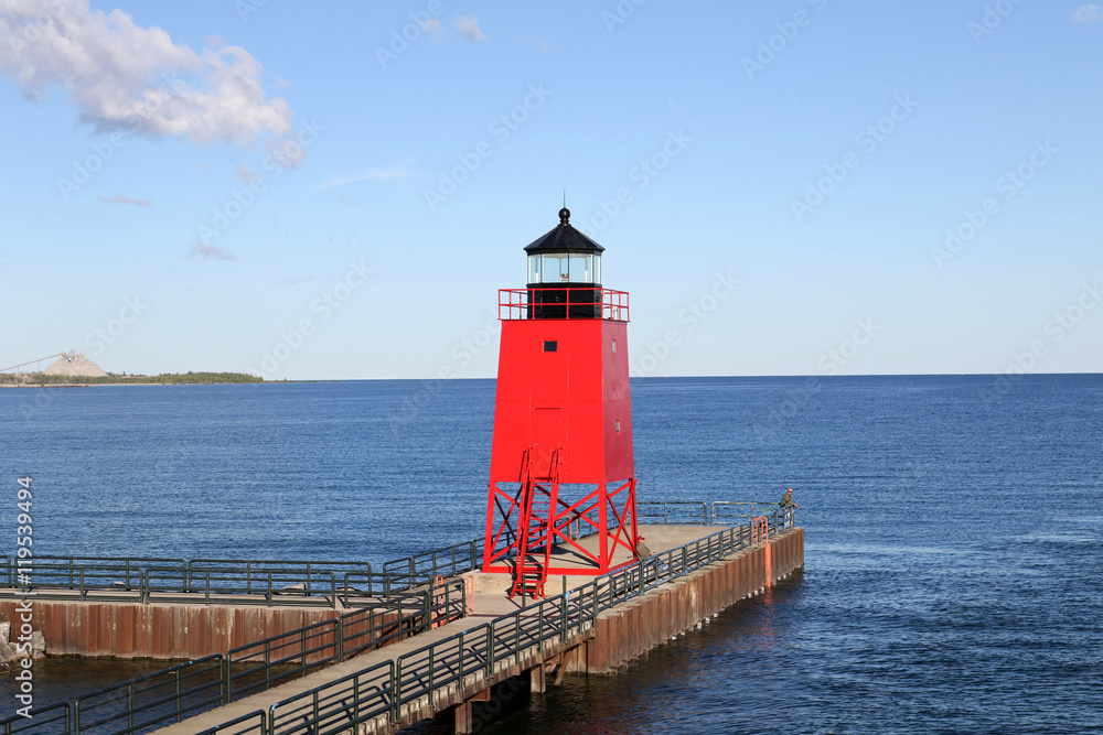 The red lighthouse at the entrance to the harbor at Charlevoix, Michigan from Lake Michigan.