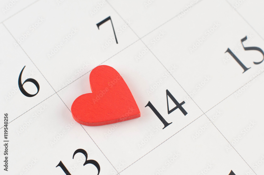 Closeup of wooden heart on the calendar page Closeup of wooden heart on the calendar page