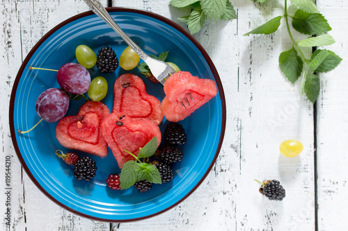 Slice of watermelon and berry fruit on wooden background, a popu photo