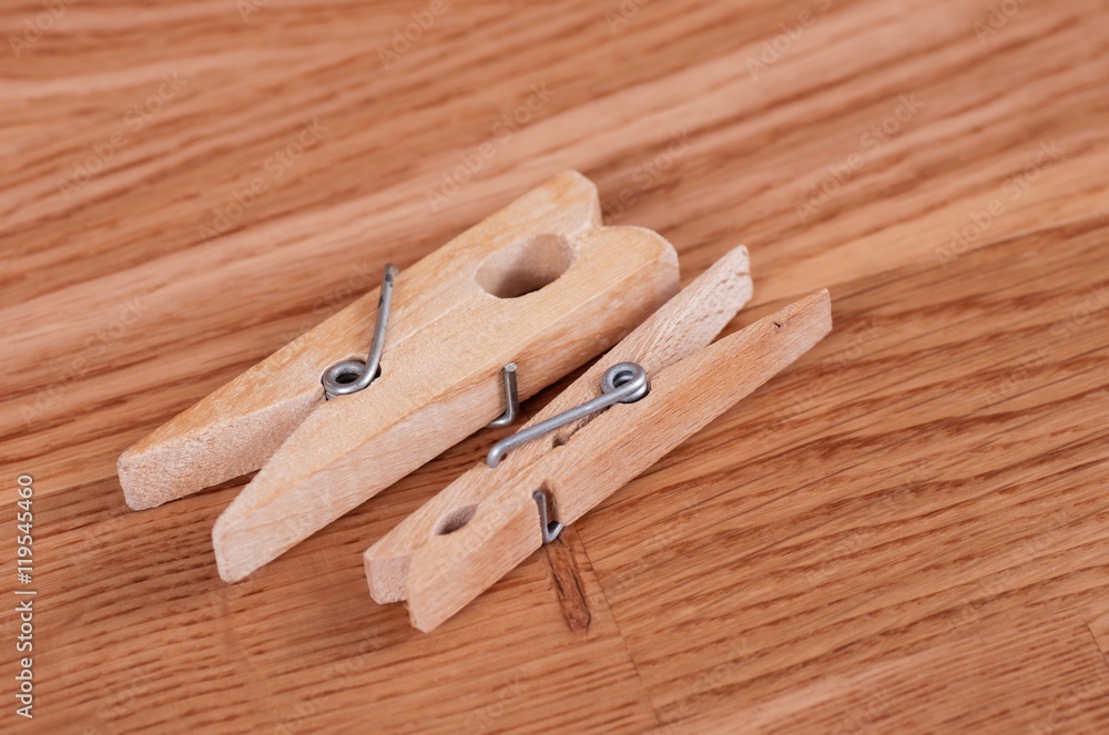 Pair wooden cloth pegs on wooden background.