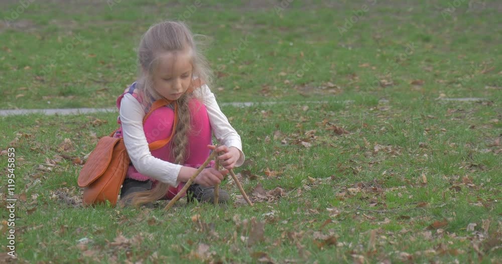 Girl Tries to Construct a Tower of Wooden Sticks Girl Tries to Construct a Tower of Wooden Sticks