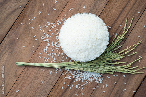 Thai jasmine rice in metal bowl with background of wooen table. photo