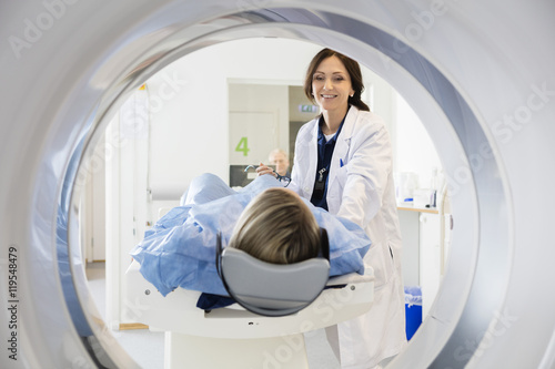 Female Doctor Looking At Patient Undergoing CT Scan photo