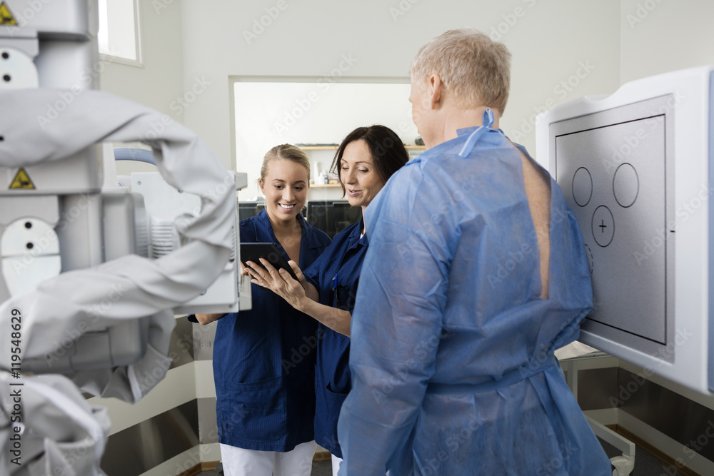 Radiologists Using Tablet Computer By Patient Radiologists Using Tablet Computer By Patient