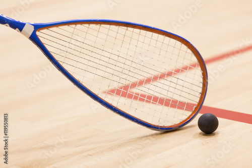 squash racket and ball over wooden background