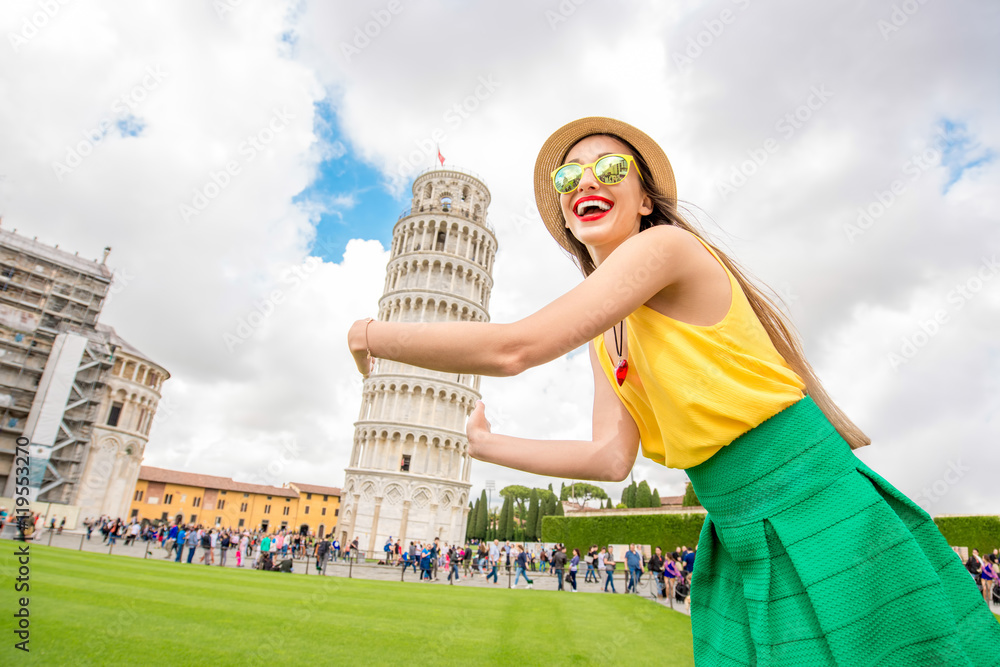 Young female traveler having fun in front of the famous leaning tower in Pisa old town in Italy. Happy vacations in Italy - obrazy, fototapety, plakaty 