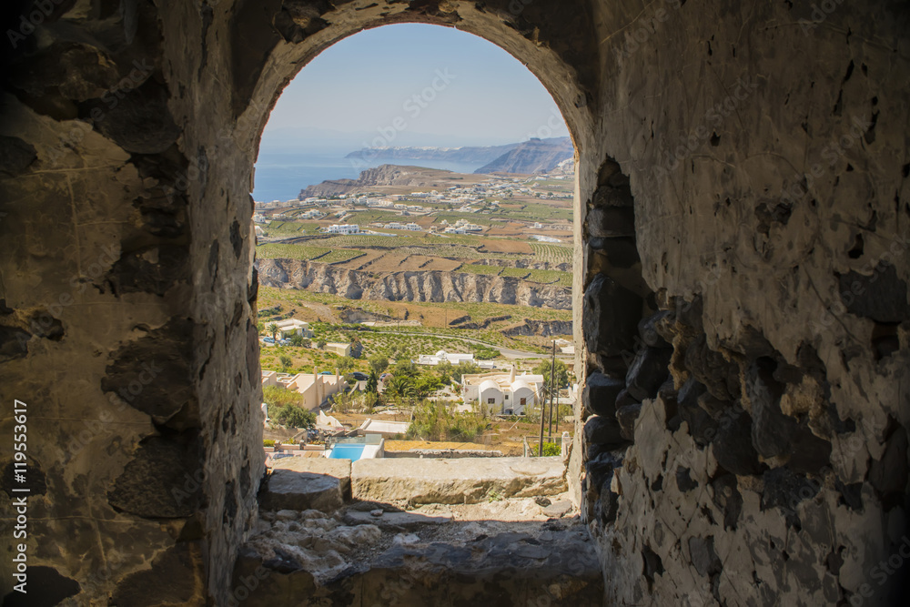 a view of the construction and building through the arch of the old house on the street of Greece, Santorini
