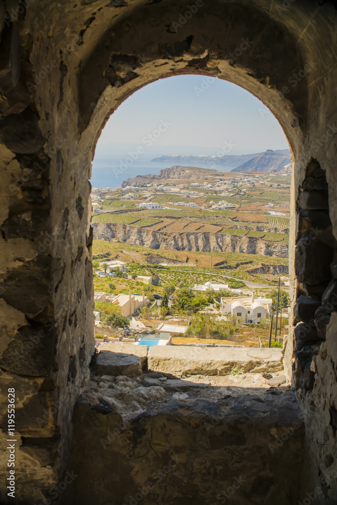a view of the construction and building through the arch of the old house on the street of Greece, Santorini