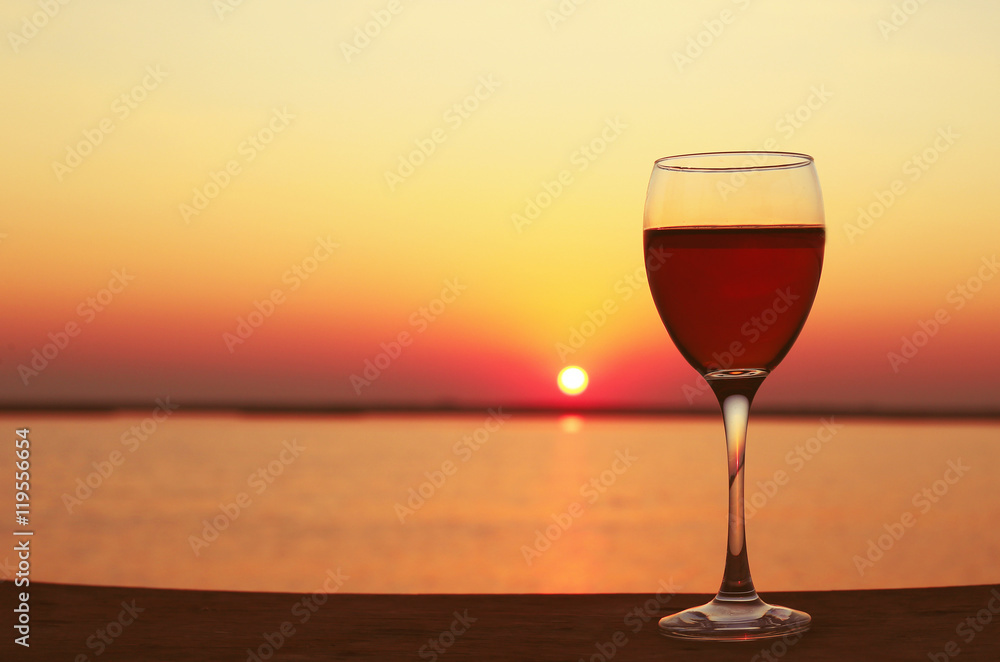 Glass of red wine on sunset background Glass of red wine on sunset background