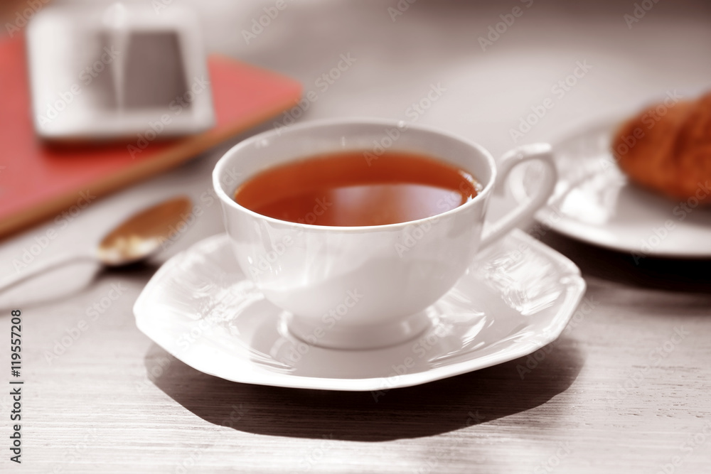 Cup of tea and spoon on wooden table