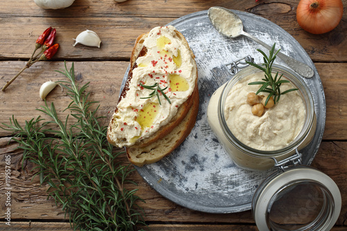 ceci humus o crema di ceci in barattolo di vetro sfondo tavolo rustico di legno photo