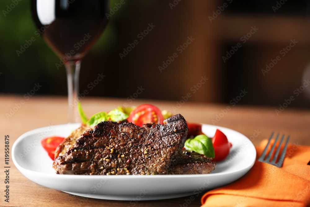 Gourmet steak with vegetables and glass of red wine on wooden table Gourmet steak with vegetables and glass of red wine on wooden table