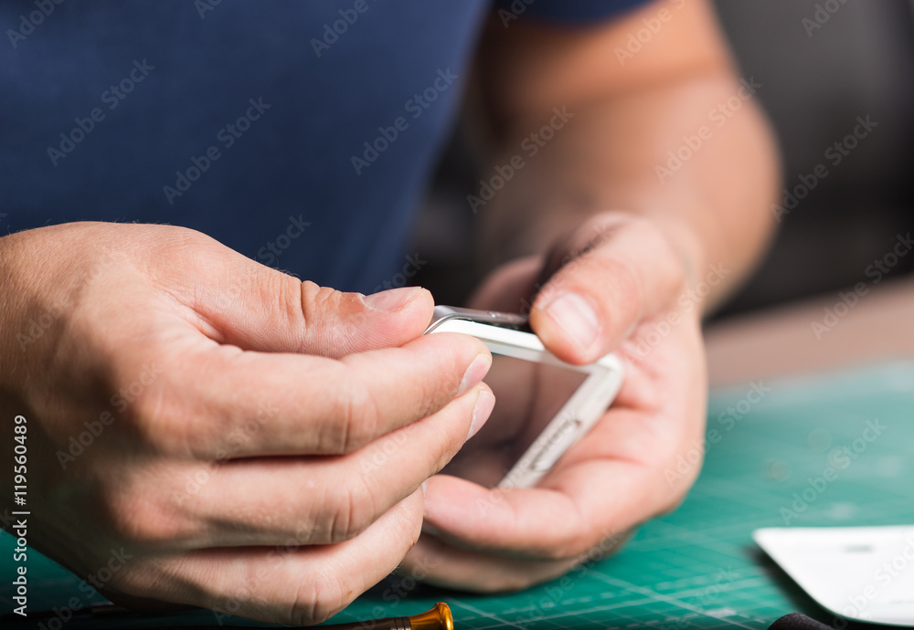 Man repairing broken smartphone, close up photo Man repairing broken smartphone, close up photo