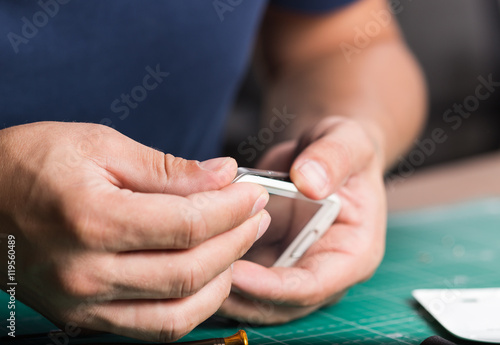 Man repairing broken smartphone, close up photo