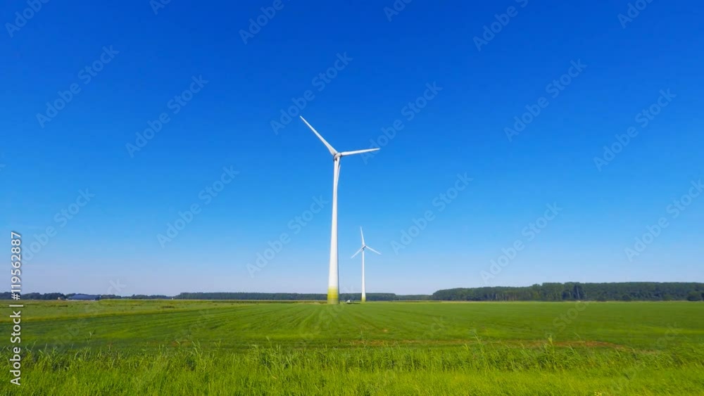 Wind turbine spinning with in a green countryside environment Wind turbine spinning with in a green countryside environment