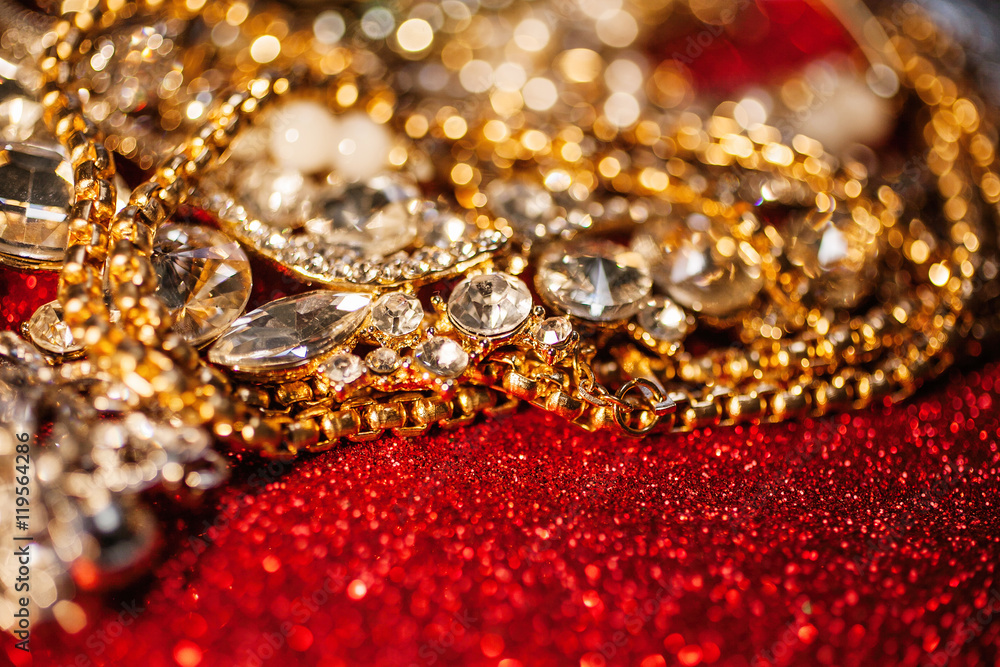 Golden and silver jewelry on red shiny glitter background Golden and silver jewelry on red shiny glitter background