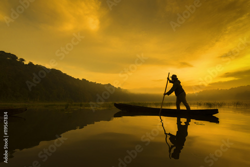 Asia silhouette fishermen on boat fishing at Tambalingan Lake, Bali Indonesia