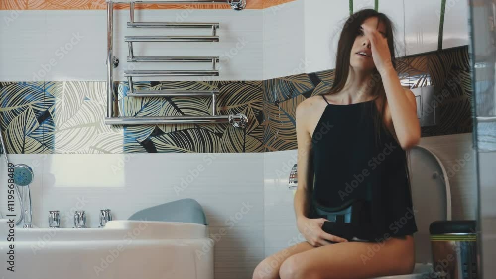 Girl sit on toilet. Put off virtual reality glasses. Bathroom. Virtual game. Gadget Girl sit on toilet. Put off virtual reality glasses. Bathroom. Virtual game. Gadget