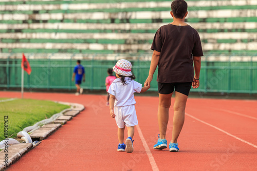 Mother holding her daughter hand and walking in running track © SKT Studio