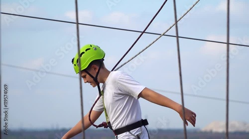 Wallpaper Mural Teenager goes on swinging beams Rope park. Teen tied lifeline Torontodigital.ca