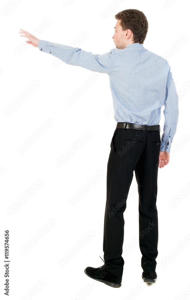 Back view of pointing business man. Isolated over white background. Businessman in a shirt and a bow tie is back and shows his hand. Back view of pointing business man. Isolated over white background. Businessman in a shirt and a bow tie is back and shows his hand.