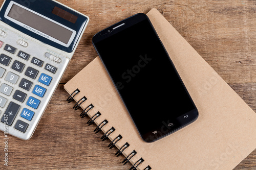 mobile phone and book note in vintage wooden desk