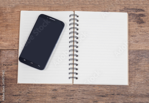 obile phone and book note in vintage wooden desk photo