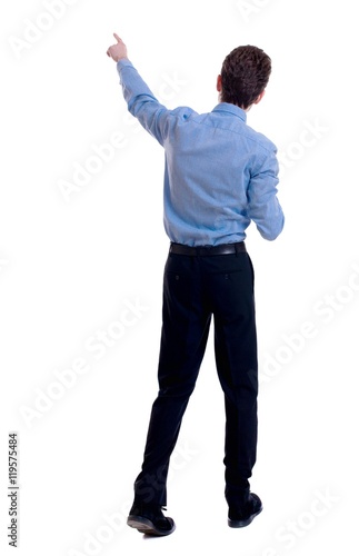 Back view of pointing business man. Businessman in a blue shirt on the move points to something interesting.