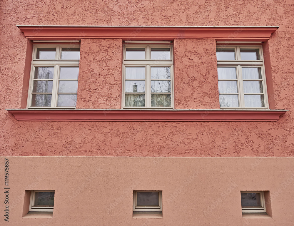 three windows row on colorful house wall