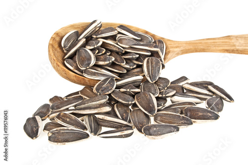 Obraz na plátně Sunflower seeds on wooden spoon on a white background