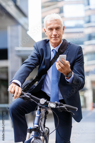 Successful businessman riding bicycle