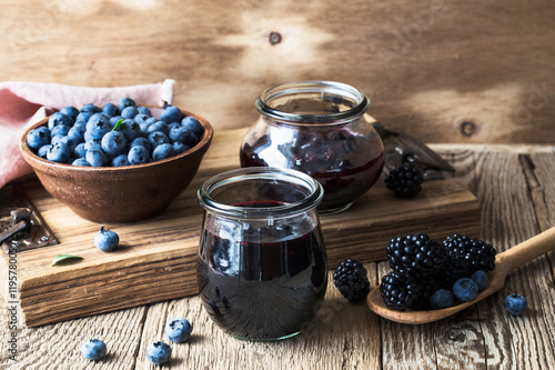 Blueberries and blackberries jam in glass jars