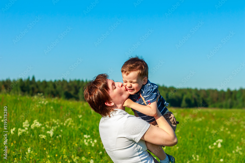 Young brunette with short hair playing with his son in the field Young brunette with short hair playing with his son in the field