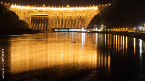 High-head hydroelectric station on the mountain river in the night with illumination