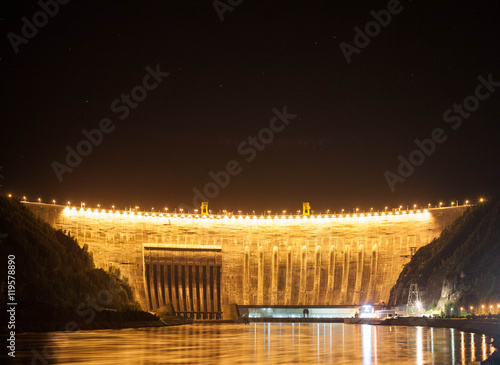 High-head hydroelectric station on the mountain river in the night with illumination photo