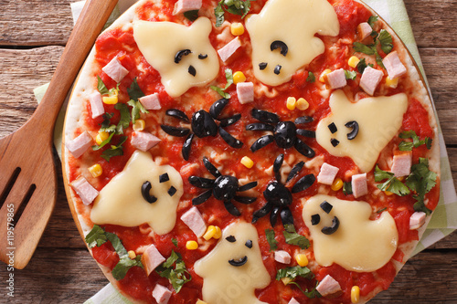 pizza for Halloween with ham, cheese and olives close-up. Horizontal top view 