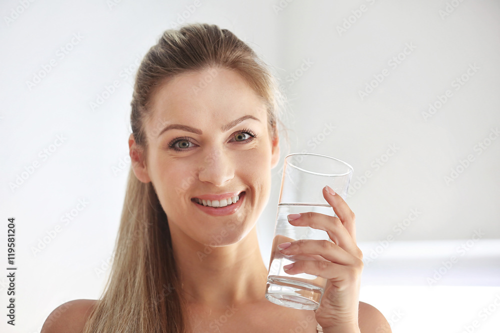 Beautiful girl drinking water on light background Beautiful girl drinking water on light background
