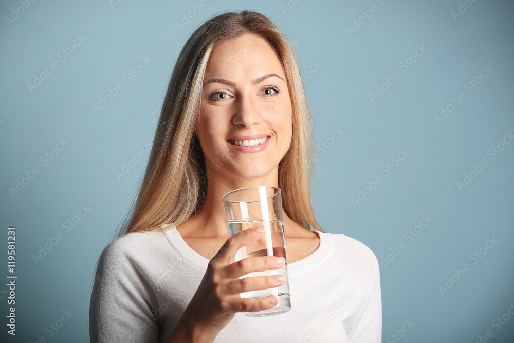 Beautiful girl drinking water on blue background Beautiful girl drinking water on blue background