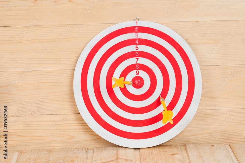Dart arrow hitting in bullseye on dartboard with money Dart arrow hitting in bullseye on dartboard with money