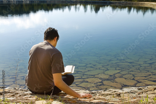 Man reading Book by lake