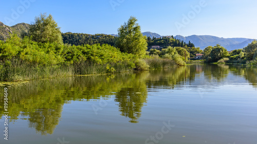 Evening view on the town Virpazar from channel. Reflection.