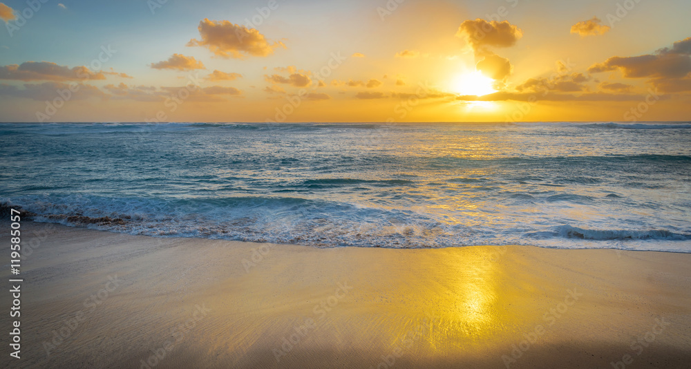 Golden sunset as a rolls onto shore