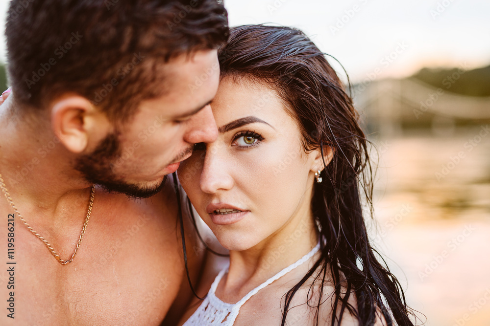 happy young couple having fun, man and woman in the sea on the beach. vintage retro style with soft focus and sun flare