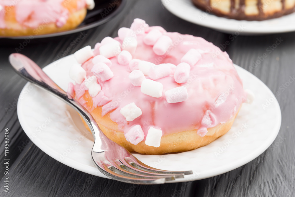 donut with pink cover and jellybeans on black