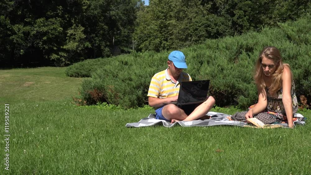 couple use different media, man work laptop, girl read book. 4K couple use different media, man work laptop, girl read book. 4K