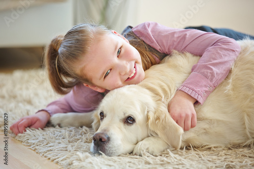 Kind kuschelt mit Golden Retriever Hund