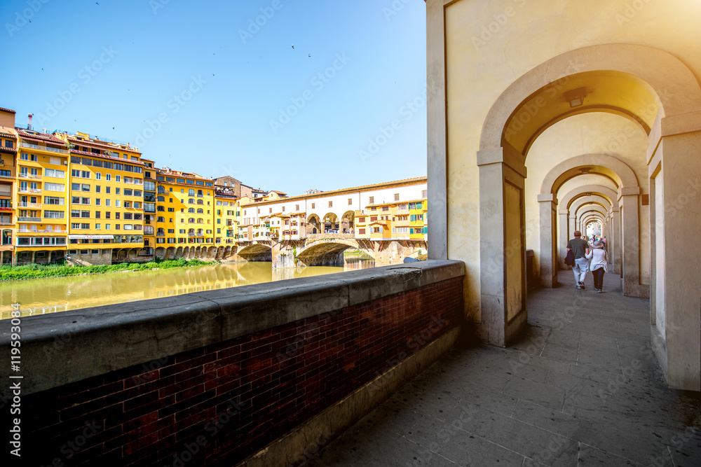 Cityscape view on famous Ponte Vecchio bridge with arch corridor in Florence
