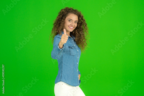 The young woman stand and smile on the green background