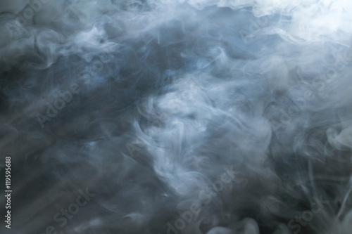 The stream of thick smoke on a dark background photo