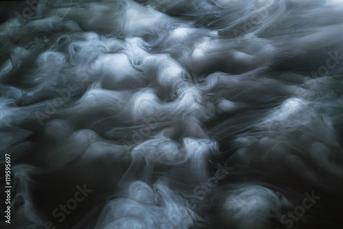 Photos The stream of thick fume on a dark background